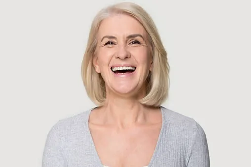 Mature woman happy smiling after dental implants